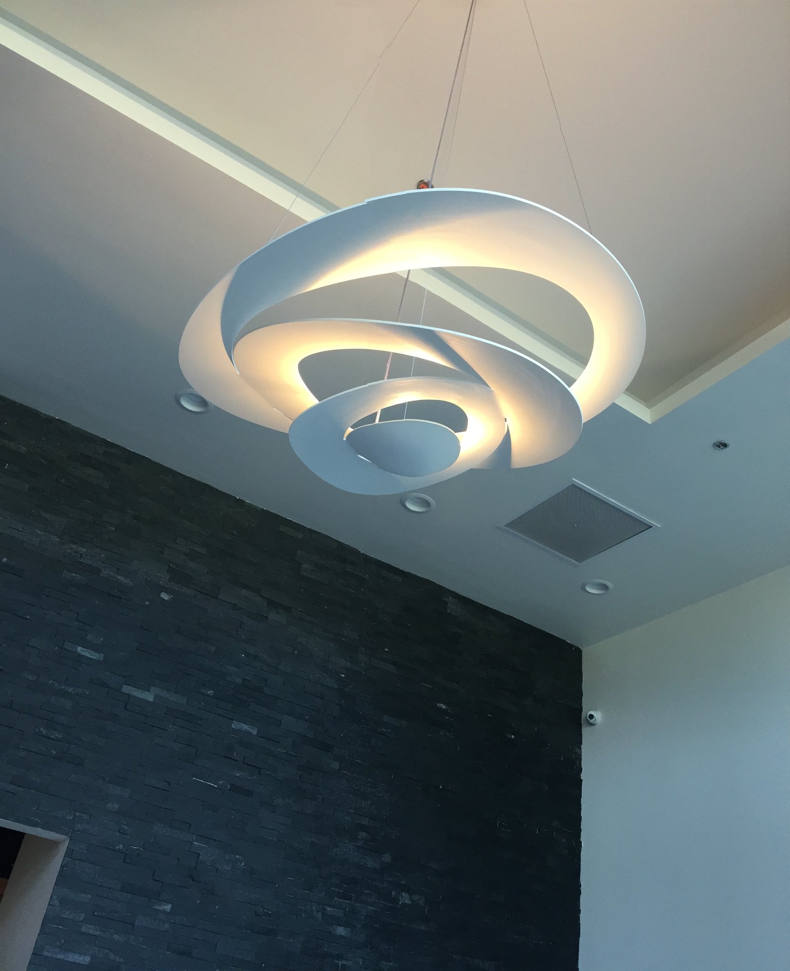 Modern chandelier and stone wall inside 18|8 Preston Hollow Village salon
